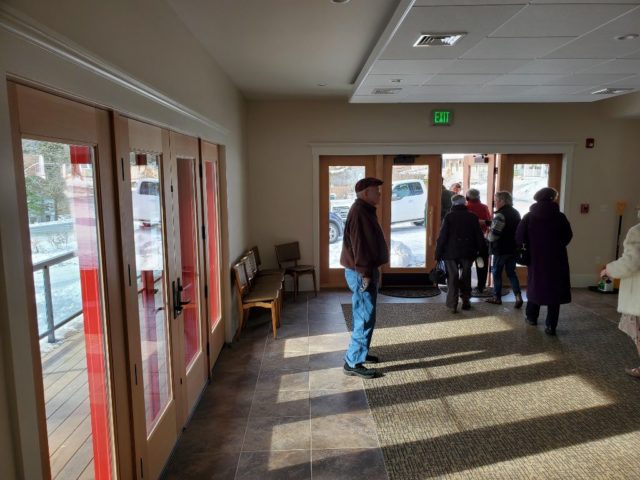 front entrance room of the new church with slate tiles and carpeting and lots of light coming through the french door type windows