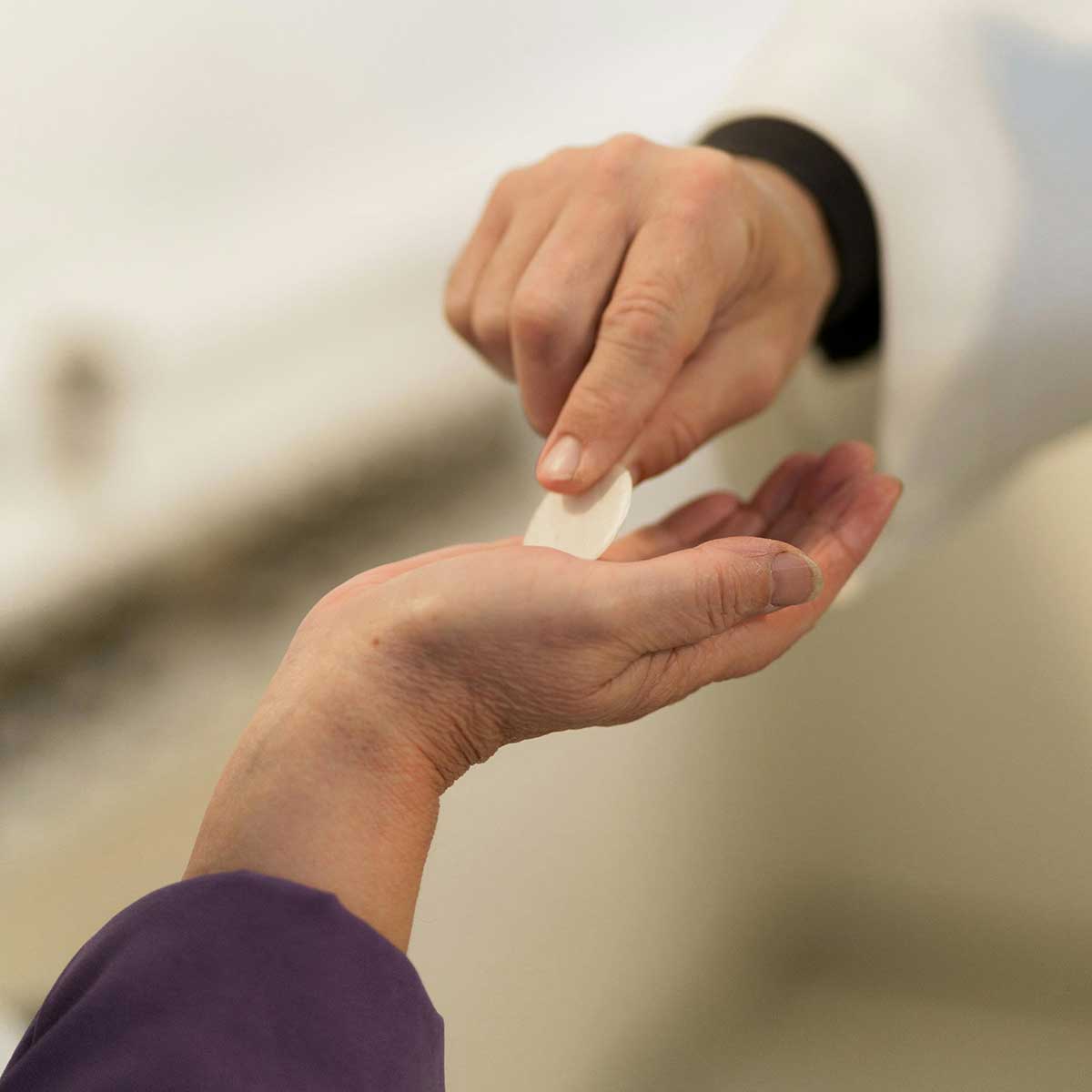 priest giving communion wafer